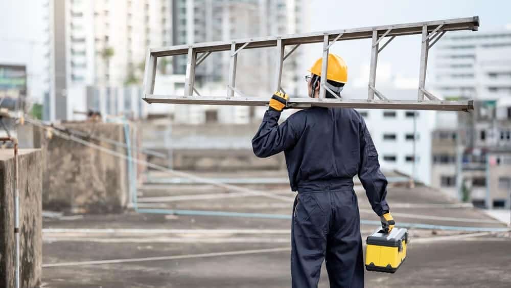 workman holding toolbox and ladder